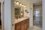 Primary bathroom with a gorgeous granite counter vanity and tile shower